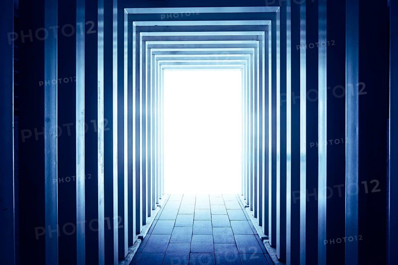 Line-shaped corridors leading to unknown bright exit door