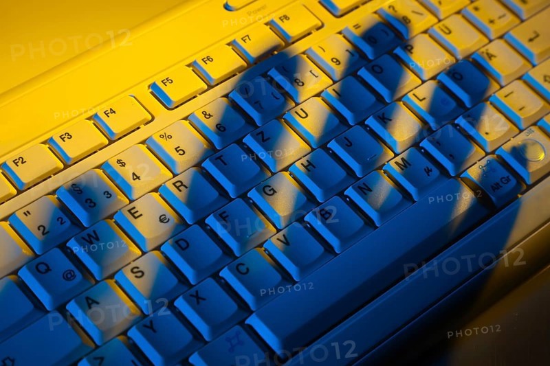Computer keyboard and the shadow of a hand. Theft of data. Austria