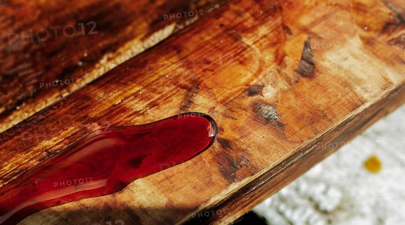 Close-up of wood stained red, emphasizing grain and texture