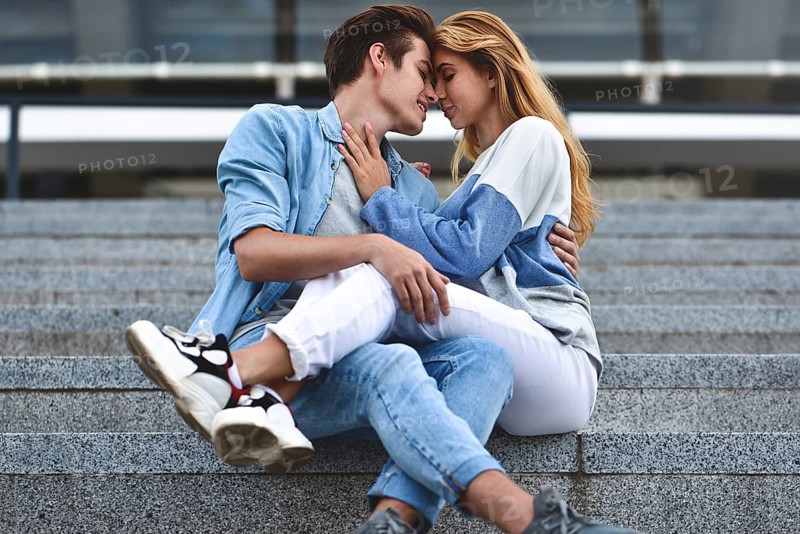 Happy to spending time together. Young beautiful couple outdoor fashion portrait. Attractive boy and girl hugging and kissing
