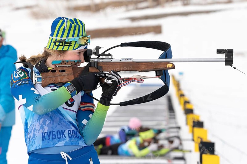 Sportswoman biathlete Legostaeva Anastasia rifle shooting in standing position. Biathlete in shooting range. Open regional youth biathlon competitions East Cup. Kamchatka, Russia, April 12, 2019, Europe