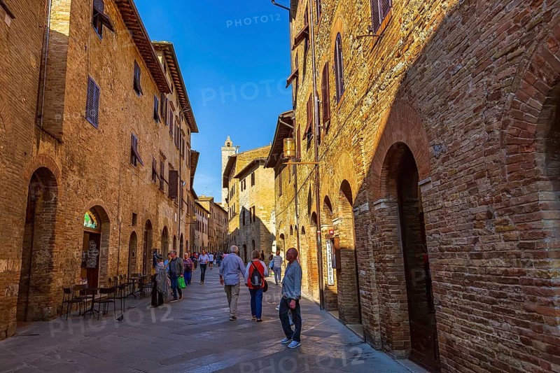 San Gimignano, Tuscany, Italy, October 25, 2018: Old medeival street and tower in typical Tuscan town, popular tourist destination, Europe