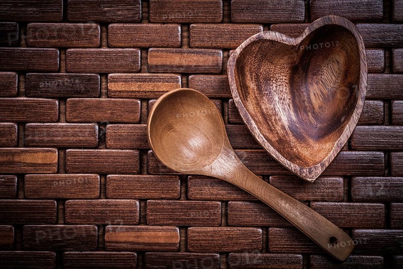 Set of heartshaped wood bowl and spoon on wooden backcloth