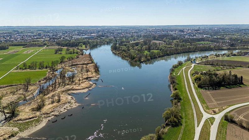 View of a river (Danube) with riverside vegetation, neighbouring fields and a town in the distance, Straubing, Lower Bavaria, drone shot