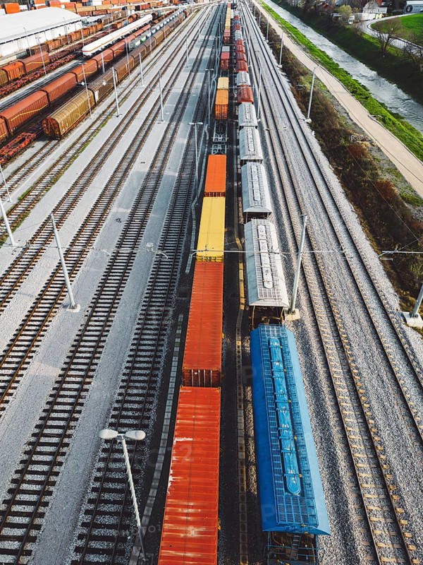 Cargo trains close-up. Aerial view of colorful freight trains on the railway station. Wagons with goods on railroad. Heavy industry. Industrial conceptual scene with trains. Top view from flying drone.