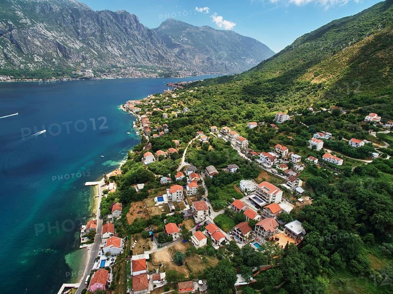 Coast of Dobrota on the shore of the Bay of Kotor at the foot of the mountains. Montenegro., Kotor Municipality, Montenegro, Europe