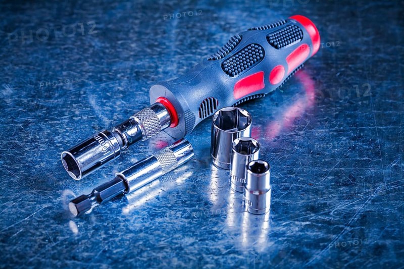 Screwdriver bit holders replaceable torxes on scratched metallic background construction concept