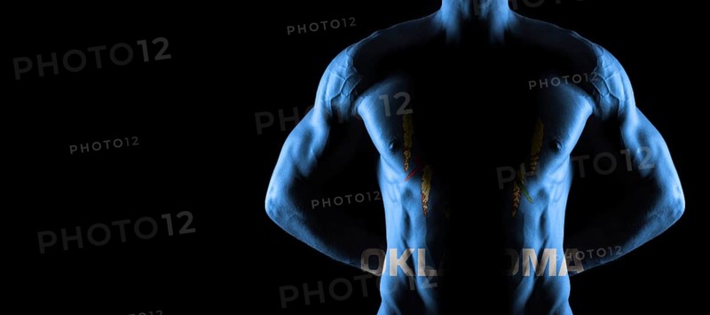 Oklahoma flag on muscled male torso with abs, Oklahoma bodybuilding concept, black background