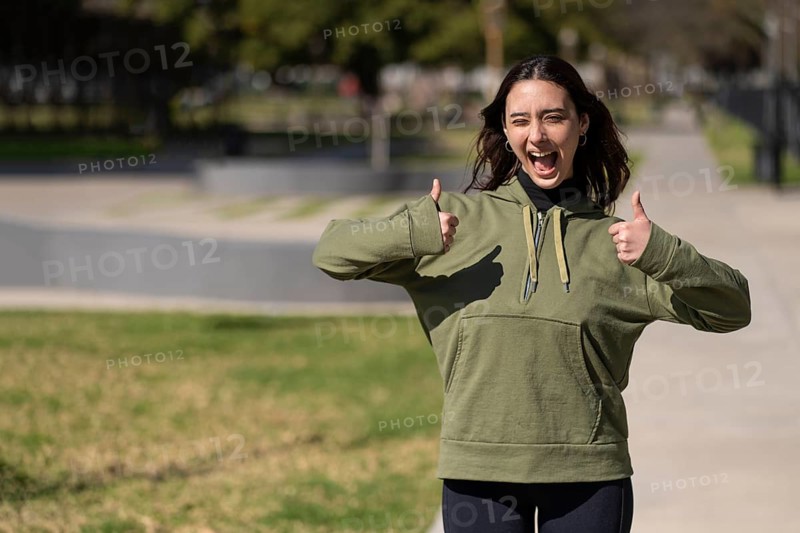 Young woman with happy expression and thumbs up