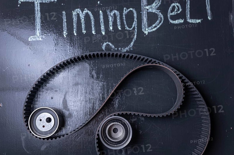 Timing belt on a blackboard with chalk writing and gears