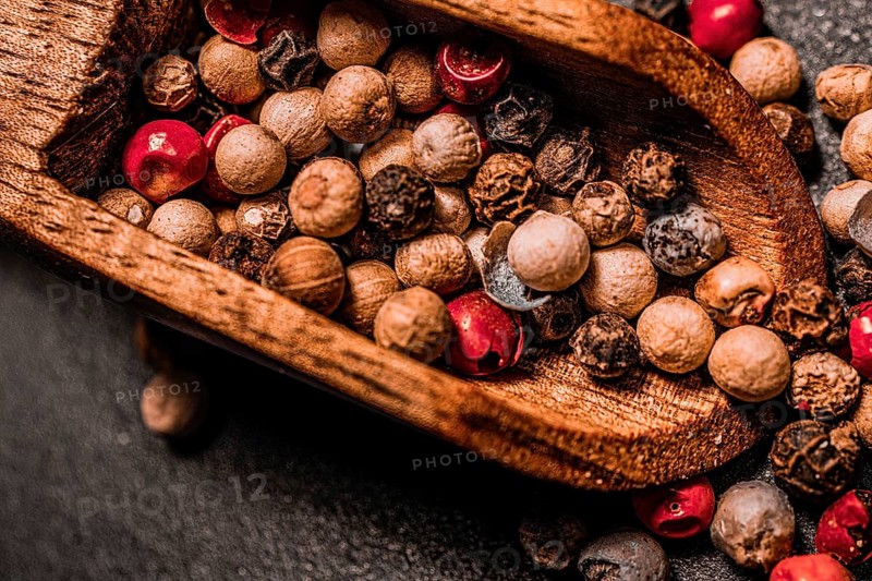 Different kind of peppercorns in a wooden spoon