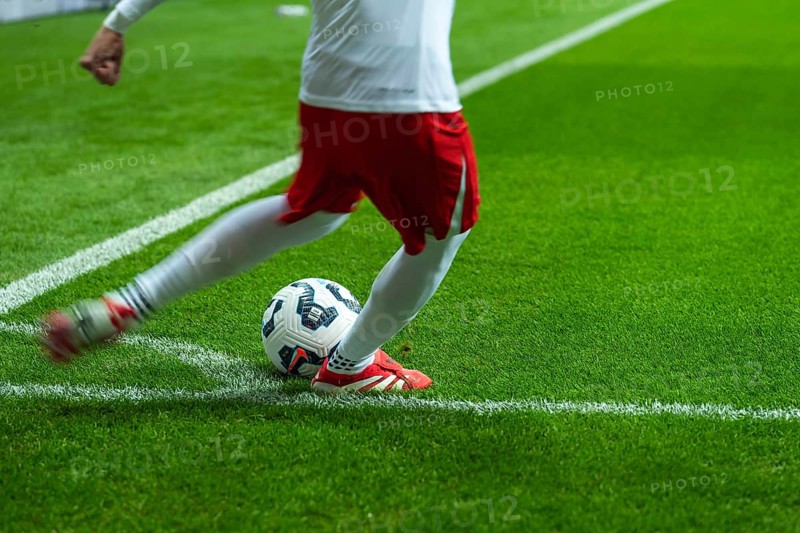 WARSAW, POLAND - MARCH 21, 2025: Qualifications for FIFA World Championship 2026. Match Poland - Lithuania. Footballer takes the corner. Detail of player's legs and the ball