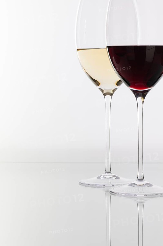 Wineglass with red and white wine on a glass table