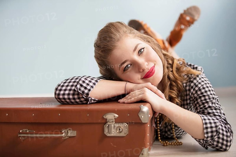 Beautiful pin up girl. Portrait of a beautiful retro woman. Girl with an old suitcase