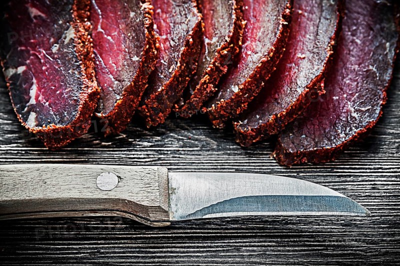 Sliced meat knife on wooden board food concept