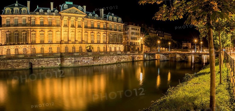 Night panoramic view with the Rohan Palace and the river Ill, with building and yellow lights reflected in its water