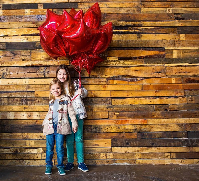 Children with balloons at wooden wall
