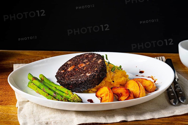 Black pudding with green asparagus and roasted apple