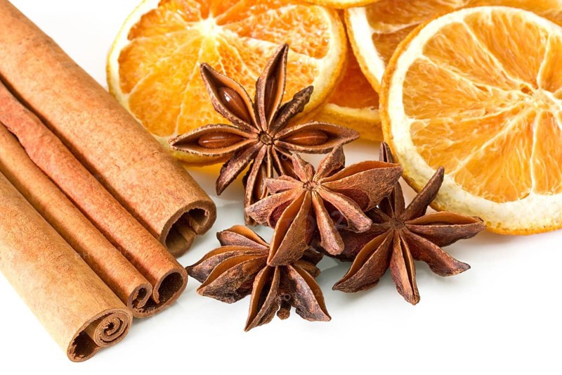 Cinnamon sticks, anise stars and orange slices on white background Cinnamon sticks, anise stars and orange slices on white background