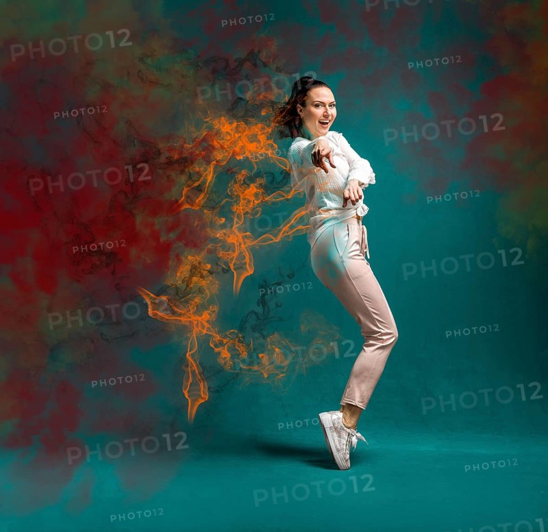 Young and beautiful dancer posing in the studio in front of a colourful background