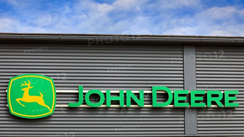 John Deere logo outside on building exterior with blue sky and clouds. Salo, Finland. June 25, 2023