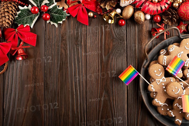 Christmas background of tray with gingerbread cookie men and rainbow flags on wooden table