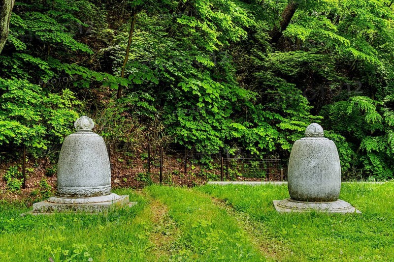 Haeinsa-gil, South Korea. May 26, 2020: Two Buddhist urns on lush lawn in front of mountain forest