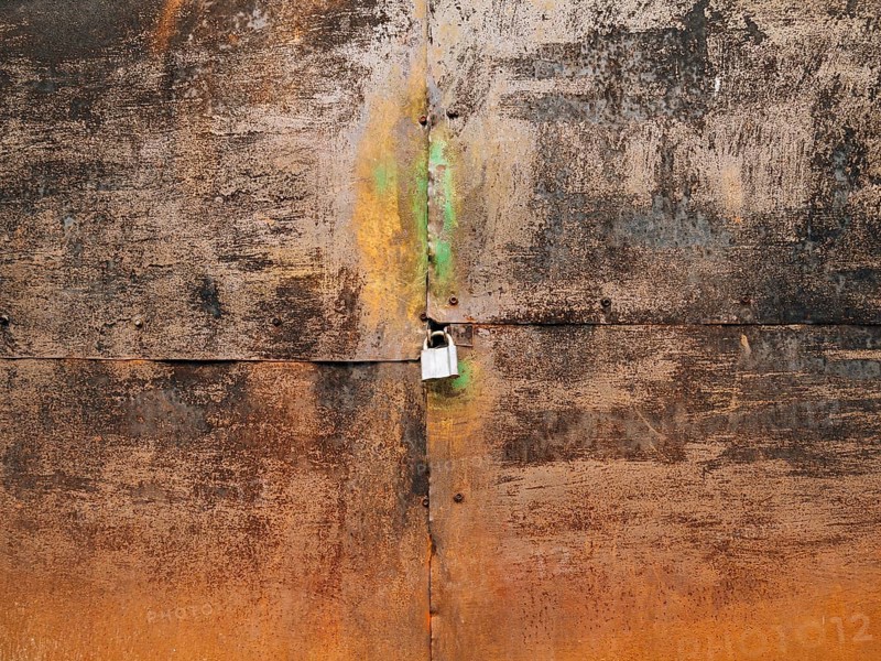 Metal rusty gate and padlock. Texture of rusty metal