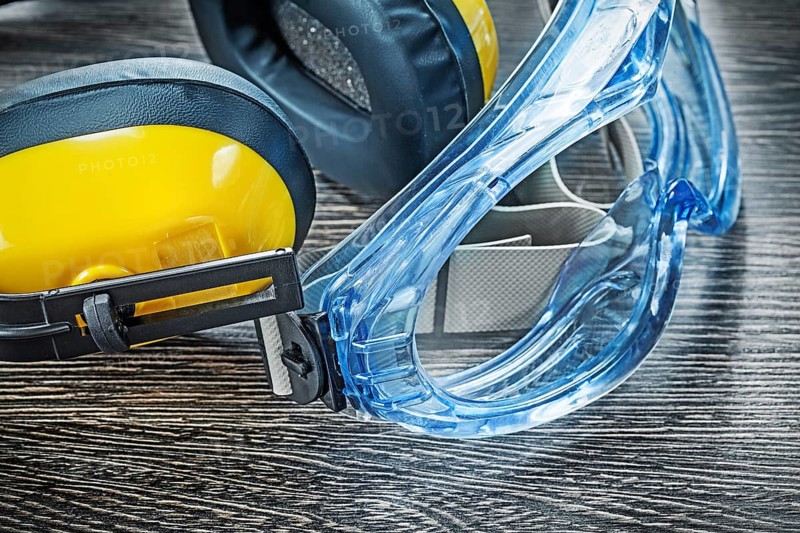 Protective spectacles earmuffs on wooden board