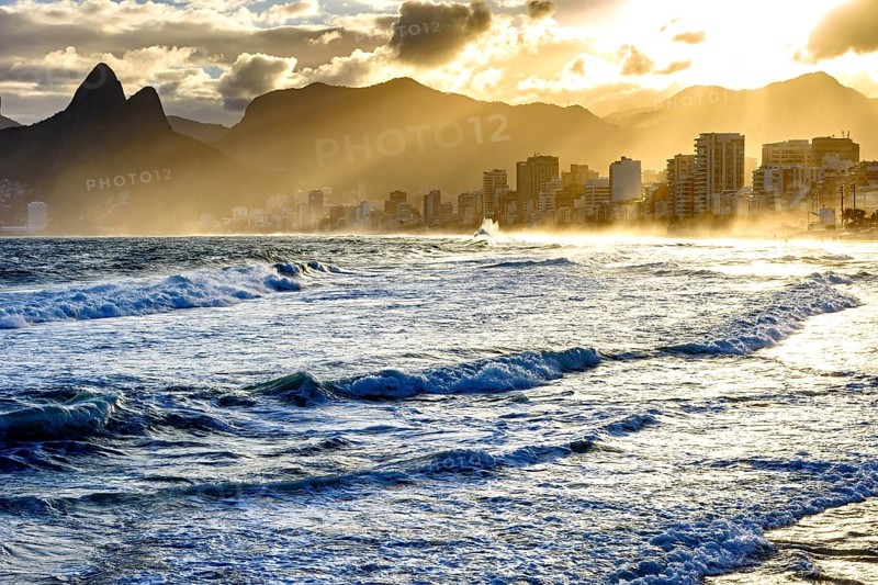 Summer sunset with cloudy sky with Two Brothers hill and Vidigal slum view from Ipanema beach at Rio de Janeiro