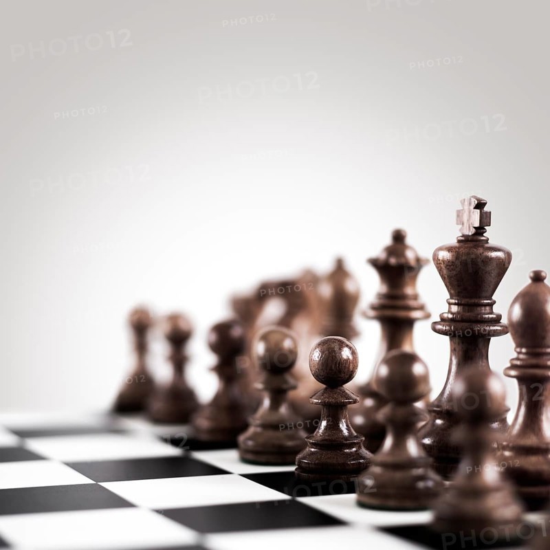 Strategy and tactics concept, black wooden chess figures on the board standing in a row ready for game