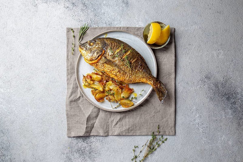Food, Grilled sea bream or dorada on gray plate. Gray background