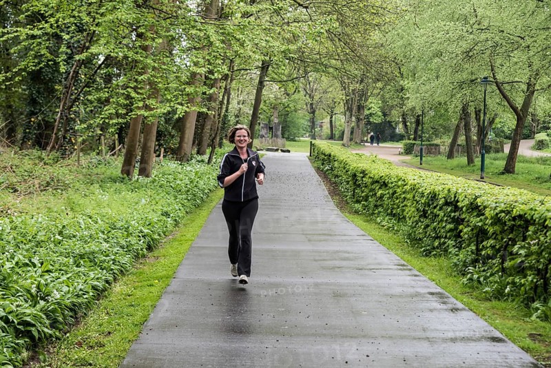 Jette, Brussels Capital Region Belgium, 04 24 2020 Attractive thirty year old woman jogging through the park