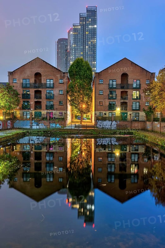 Old buildings and modern skyscrapers at night, seen in Castelfield, Manchester