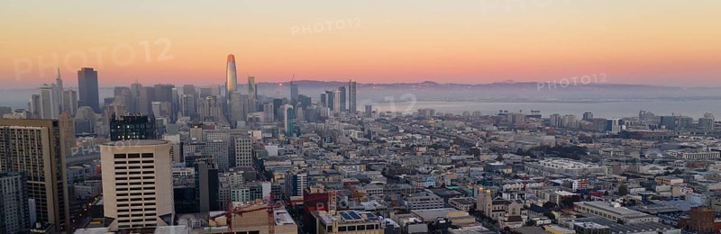 Orange hues seem to bounce off the tallest building as night comes to the San Francisco Bay area