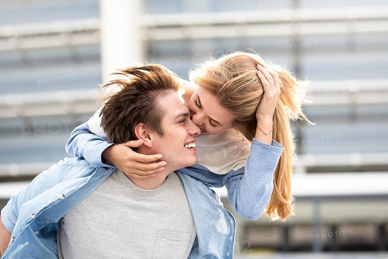 Happy to spending time together. Young beautiful couple outdoor fashion portrait. Attractive boy and girl hugging and kissing