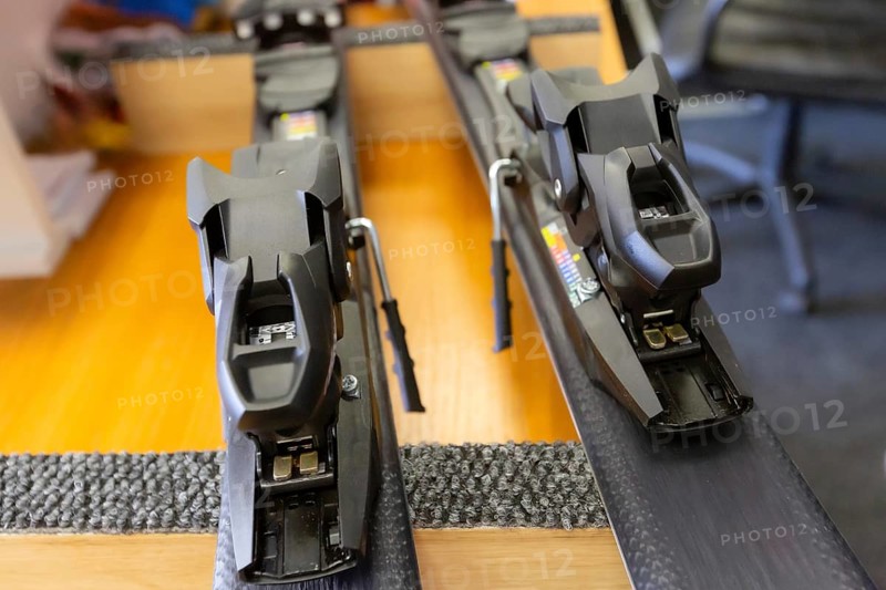 Ski center repair service shop, adjust the bindings and boots equipment on the table. Winter rent and sale