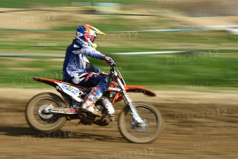 Unrecognized athlete riding a sports motorbike on a motocross racing event. Exreme sports high speed