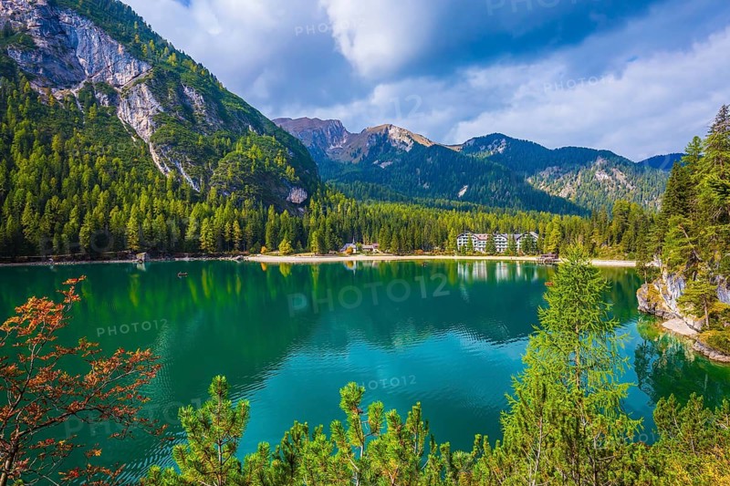 Green water reflects the surrounding mountains and forest. Magnificent lake Lago di Braies. South Tyrol, Italy. The concept of walking and eco-tourism