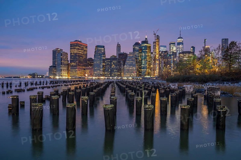 Illuminated Skyline of Lower Manhattan and River with Piers at Twilight. New York City