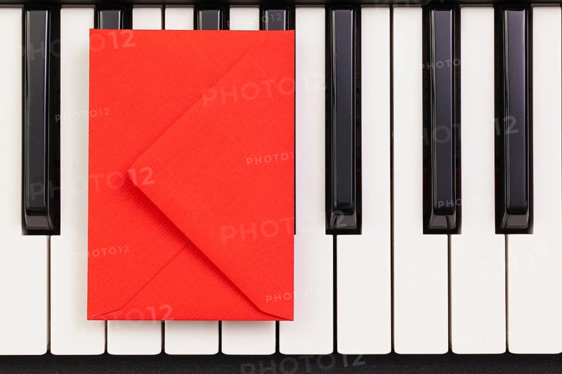 Funny arrangement envelope on the piano keybords - Flat lay image