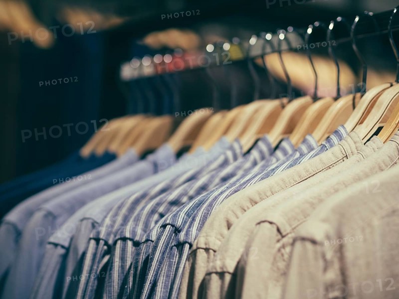 Close up view of man clothes hang in clothes store. Hangers with different male clothes. Copy space. Selective focus. Toned image