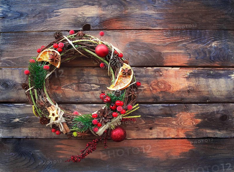 Christmas decoration on wooden background. Wreath with spice and red berries