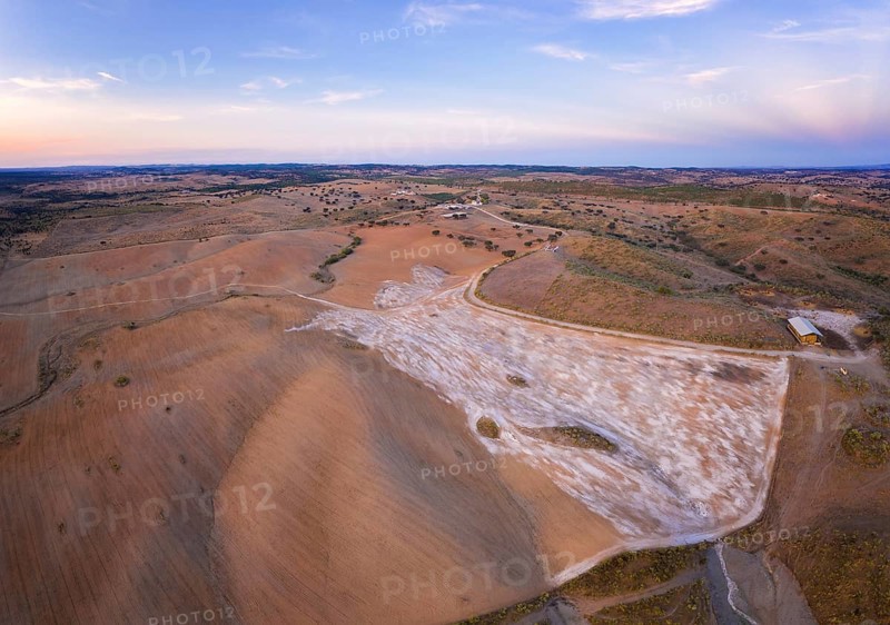 Drone aerial panorama of a desert like hill landscape with marble stones dust at sunset in Terena, Portugal, Europe