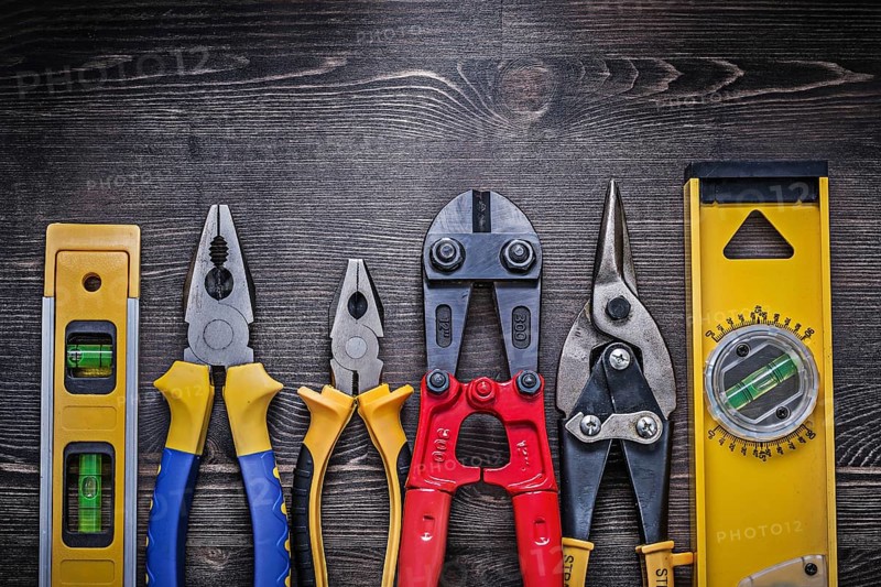 Tin snips steel cutter pliers construction level on wooden board
