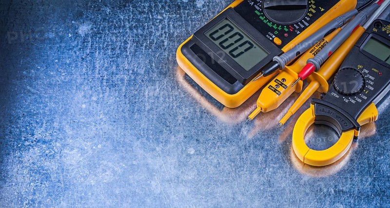 Digital ammeter electric tester multimeter on metallic background