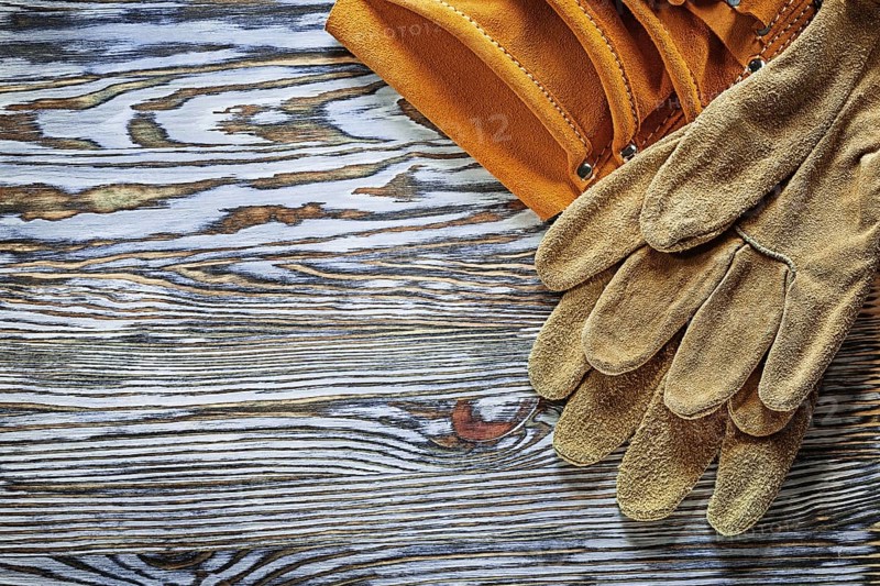 Leather protective gloves building belt on wooden board