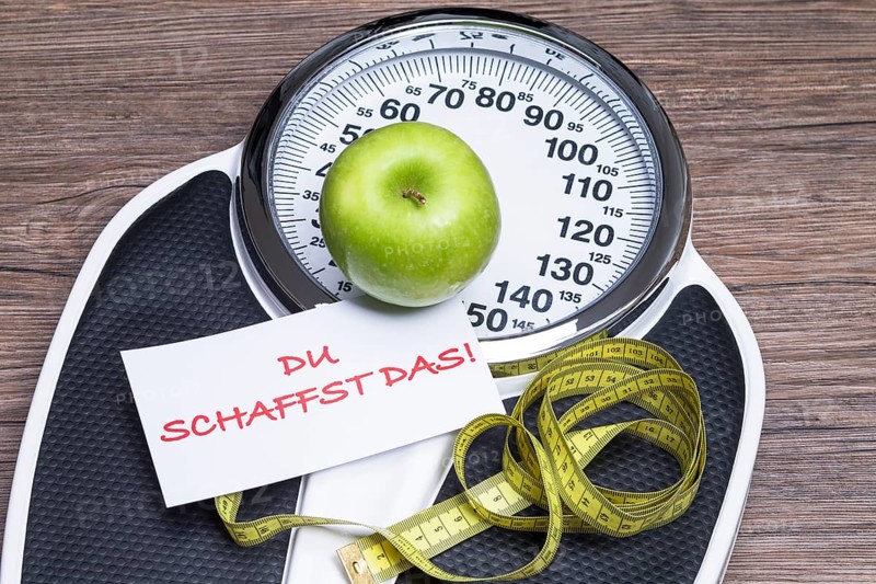 Concept photography for a healthy lifestyle with scales, apple and measuring tape