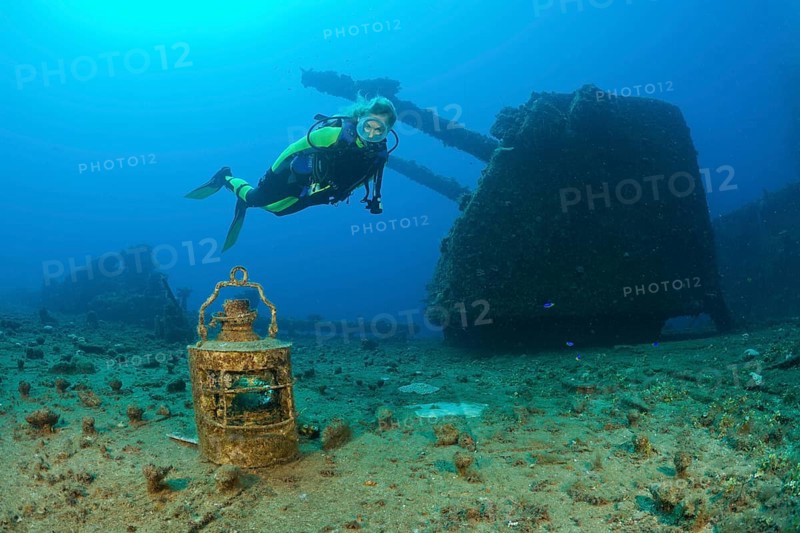 Diver finds lamp in front of 8-inch twin gun on USS Saratoga, Marshall Islands, Bikini Atoll, Micronesia, Pacific Ocean, Oceania