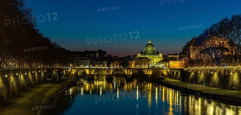 A picture of the St. Angelo Bridge, the St. Peter's Basilica and the Tiber river at night
